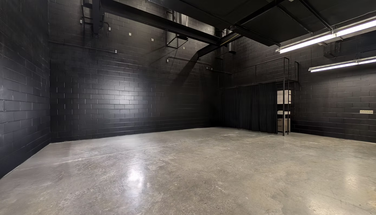 Blacked-out open stage floor with polished concrete