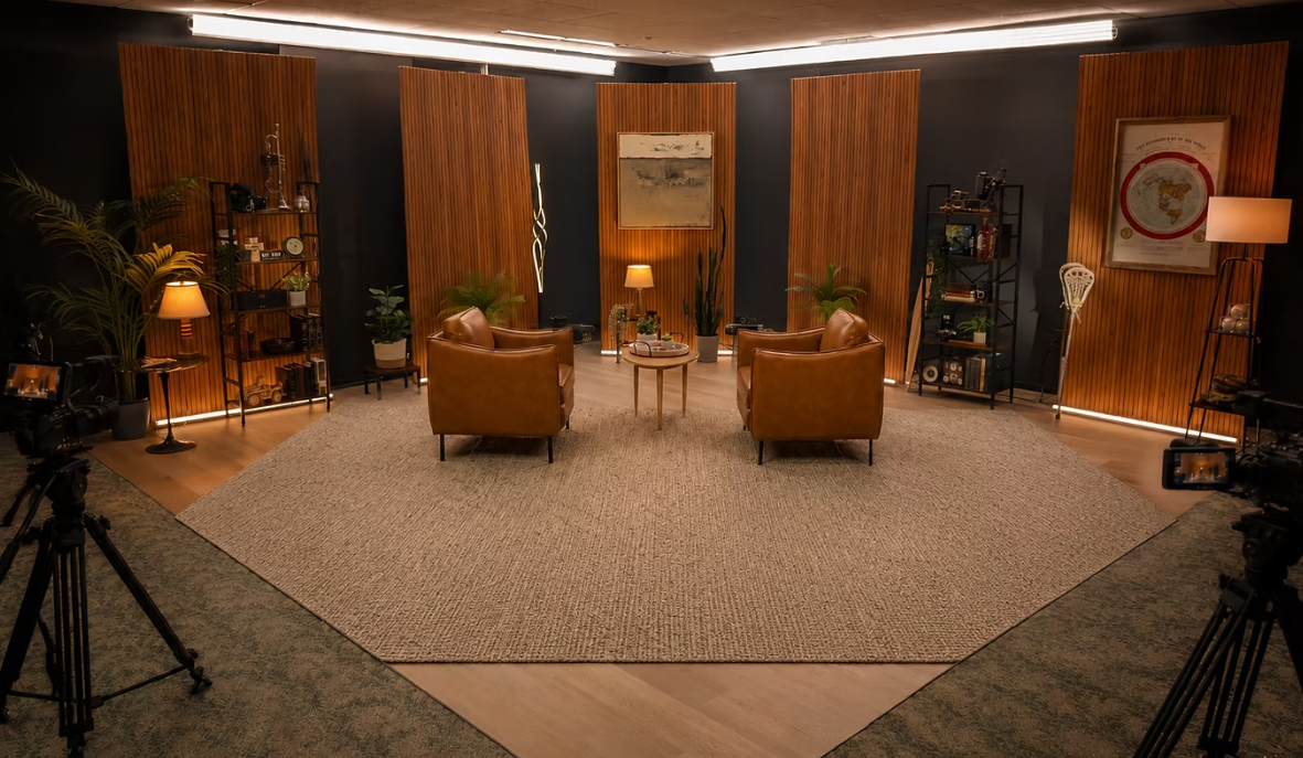 Warm wood-panelled podcast set with two leather chairs and multi-camera coverage